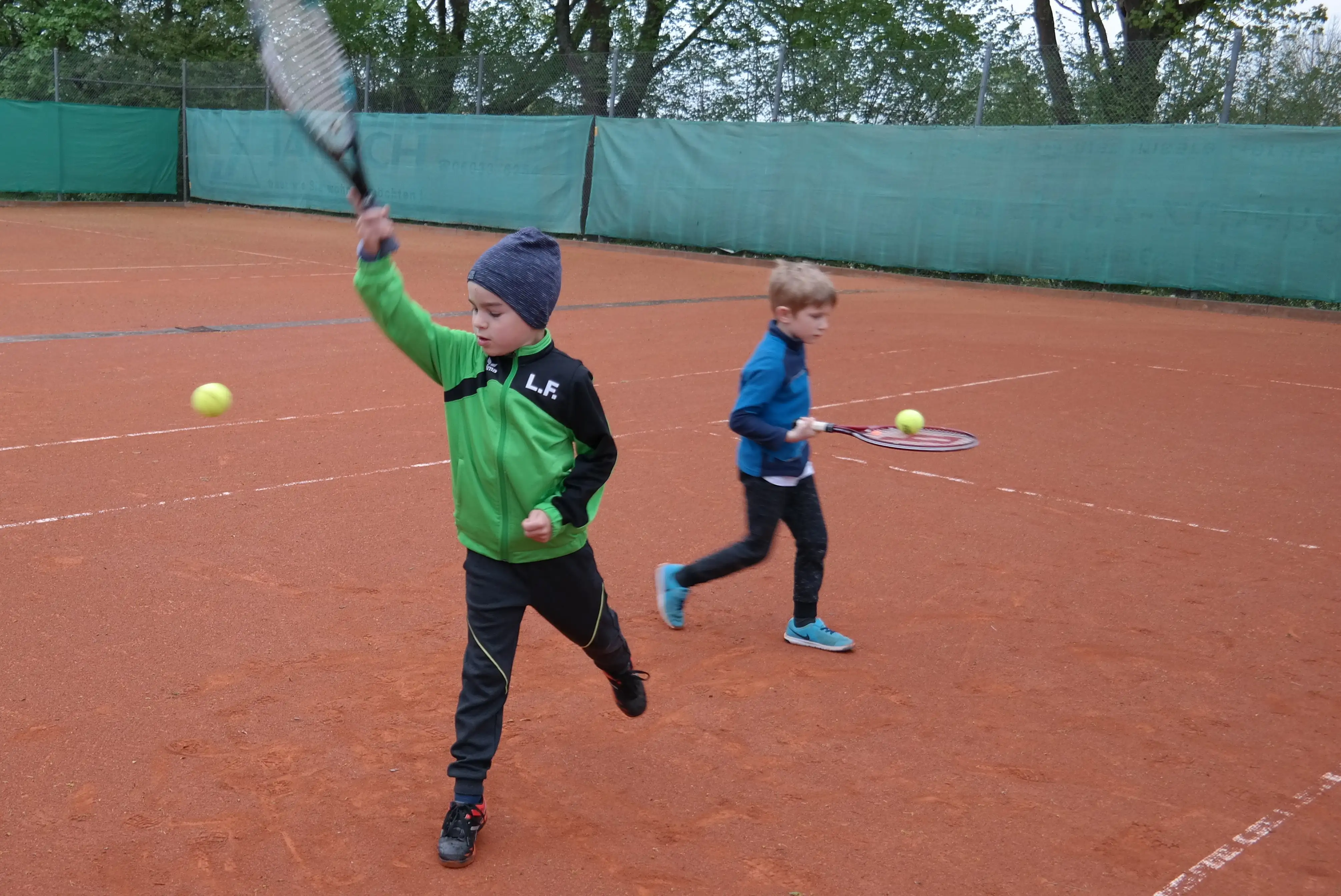 Kinder trainieren Grundschlag im Tennis